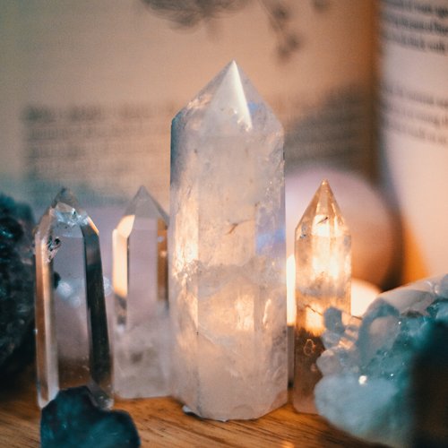 polished crystals sitting on a slab of wood with light reflecting from behind. Are you wanting to expand your tools for witchcraft? These must-have crystals for witches may be just what you are looking for!